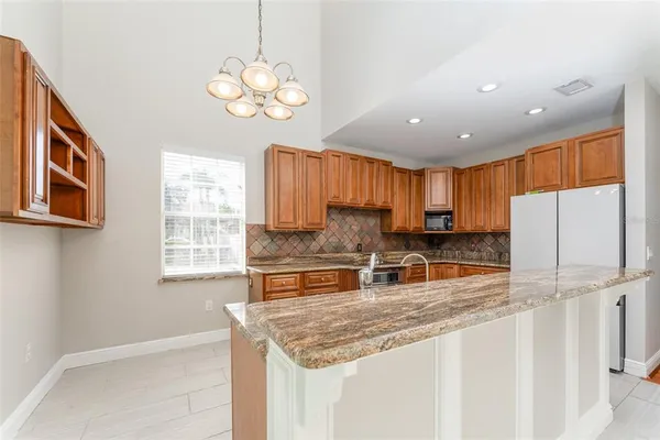 a kitchen with stainless steel appliances granite countertop a sink a stove and a refrigerator