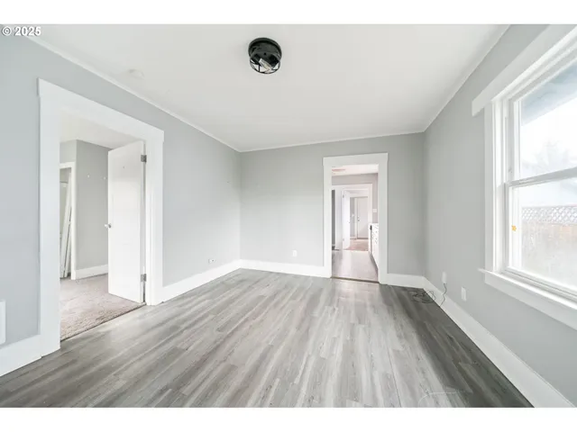 wooden floor in an empty room with a window