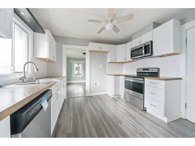 a kitchen with granite countertop a sink stainless steel appliances and cabinets