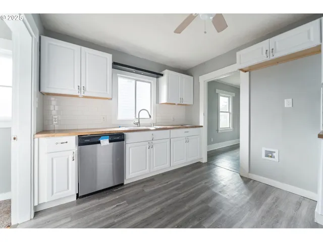 a kitchen with stainless steel appliances granite countertop a sink a stove and cabinets