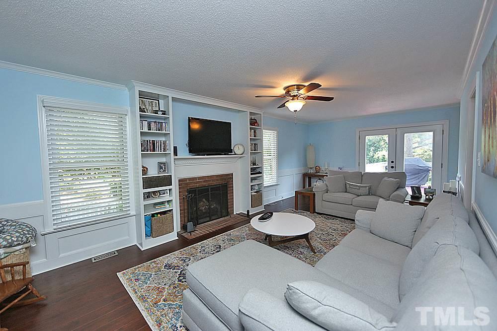 2204 Quail Ridge Road Raleigh, NC 27609 - Photo 7 of 25 a living room with furniture a fireplace and a flat screen tv