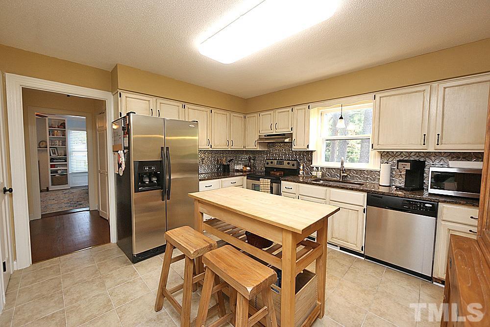 2204 Quail Ridge Road Raleigh, NC 27609 - Photo 8 of 25 a kitchen with stainless steel appliances granite countertop a refrigerator a stove a sink a dining table and chairs
