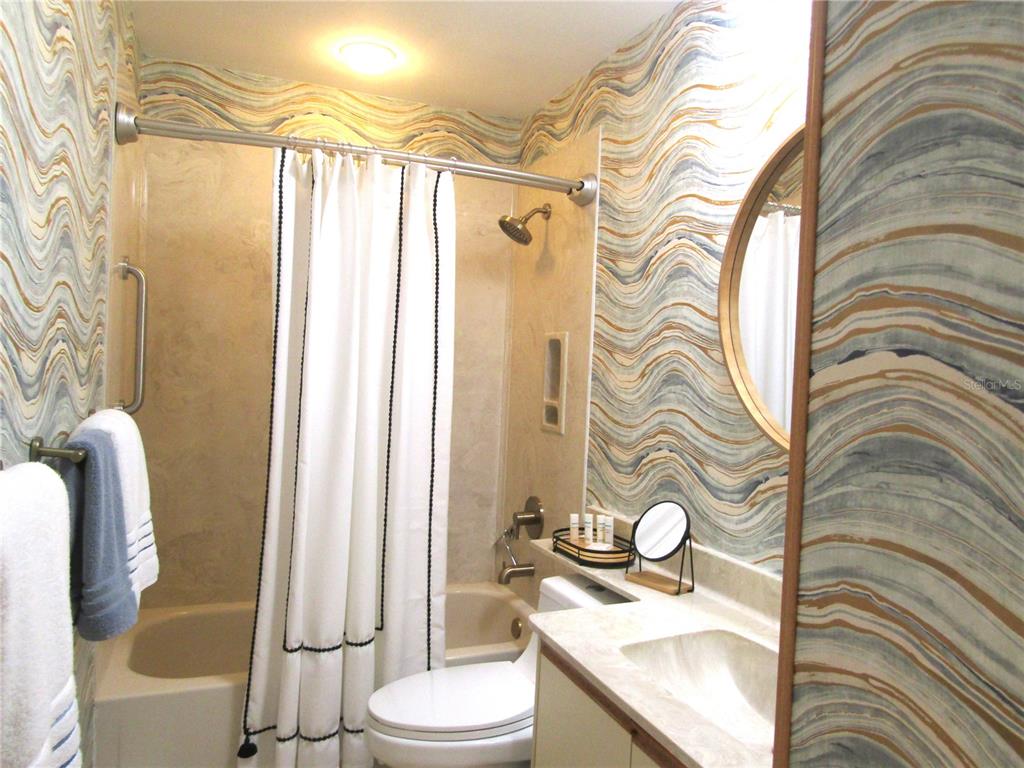 4521 Morningside, Unit 6 Sarasota, FL 34235 - Photo 13 of 22 a bathroom with a sink a toilet and shower curtain