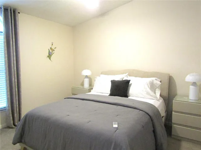 a bedroom with bed and a night stand