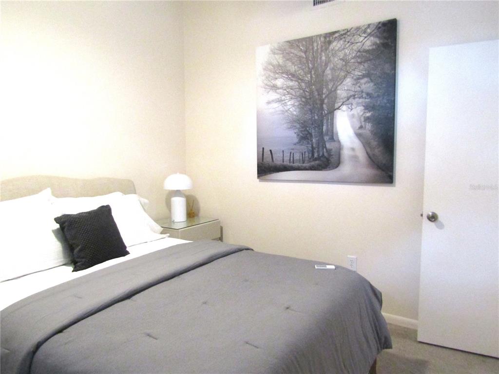 4521 Morningside, Unit 6 Sarasota, FL 34235 - Photo 18 of 22 a bedroom with a bed and a painting on the wall