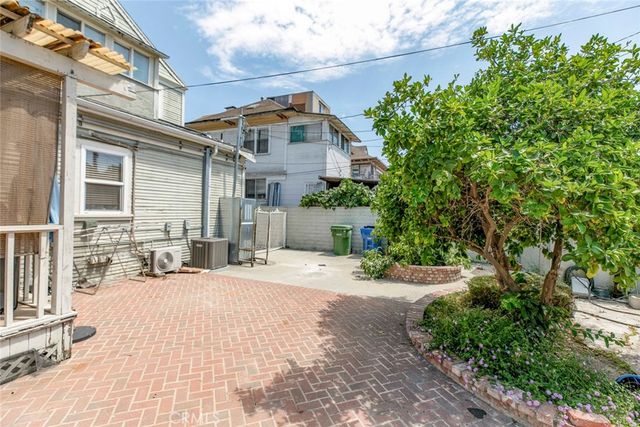 a view of a house with a small yard and potted plants