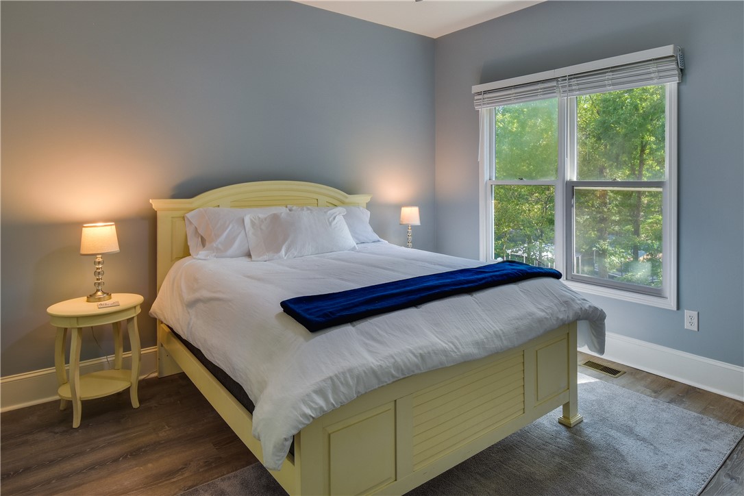 206 Petty Road Seneca, SC 29672 - Photo 23 of 48 Well-lit sleeping quarters with rich flooring, offering serene outdoor views through the large window.