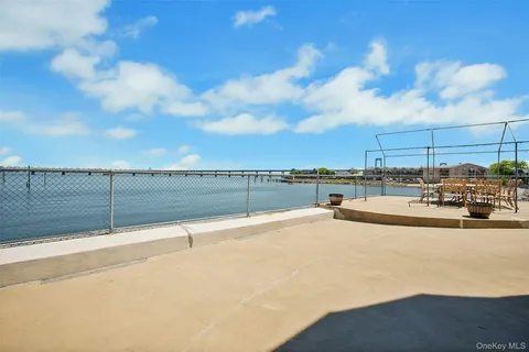 a view of a roof deck with couches and sky view