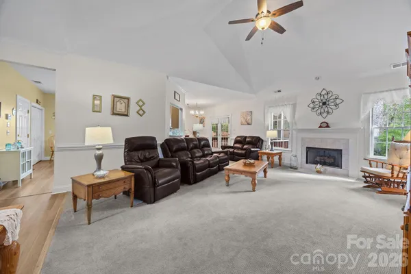 a living room with furniture a fireplace and a large mirror