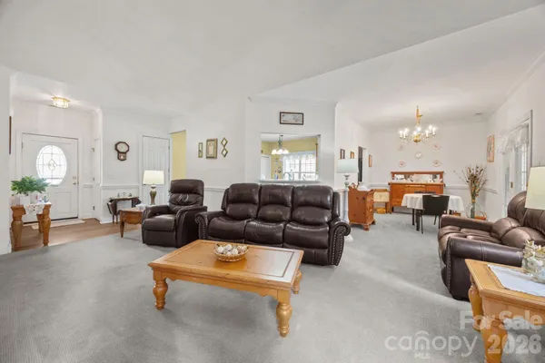 a living room with furniture and a chandelier