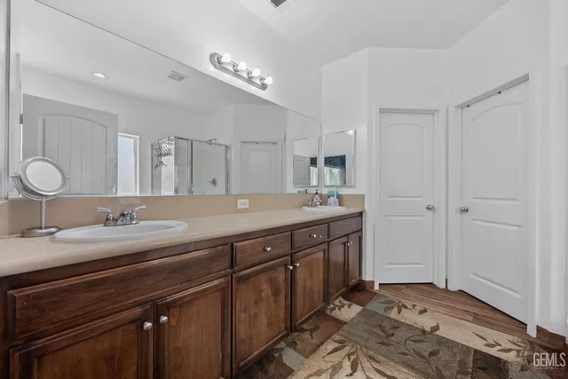 a spacious bathroom with a double vanity sink and a mirror