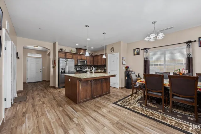 a kitchen with a dining table chairs and refrigerator