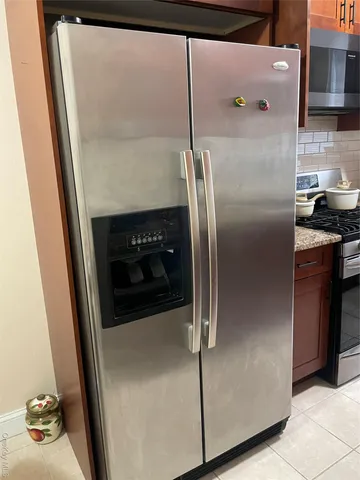 a metallic refrigerator freezer sitting in a kitchen