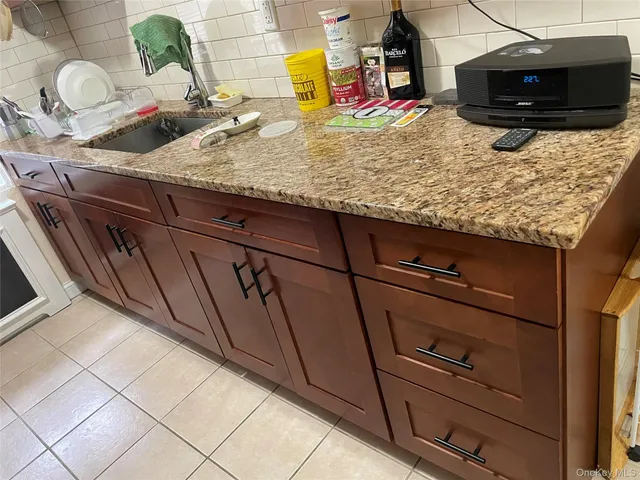 a kitchen with granite countertop white cabinets and stainless steel appliances