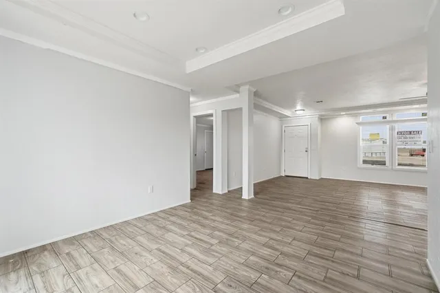a view of an empty room with wooden floor