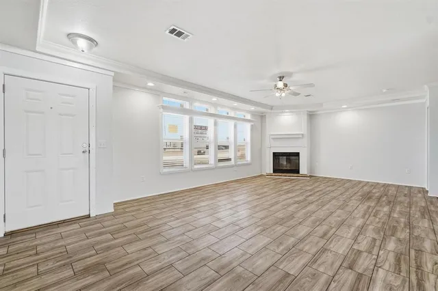 a view of an empty room with a window and a kitchen