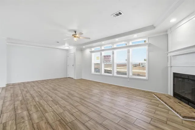a view of an empty room with a fireplace and a window