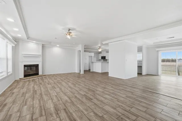 a view of empty room with wooden floor and fireplace