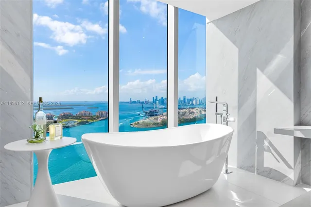 a white bath tub sitting in a bathroom next to a white tub