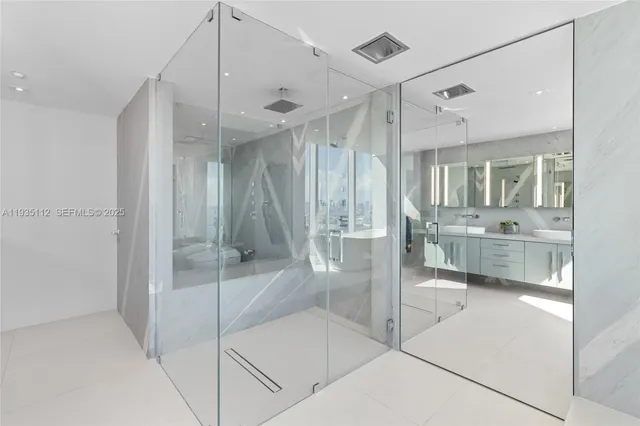 a bathroom with a glass shower door and a sink