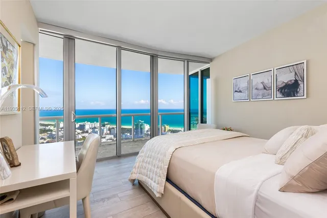 a bedroom with a large window and a balcony