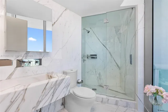 a bathroom with a sink a toilet and shower