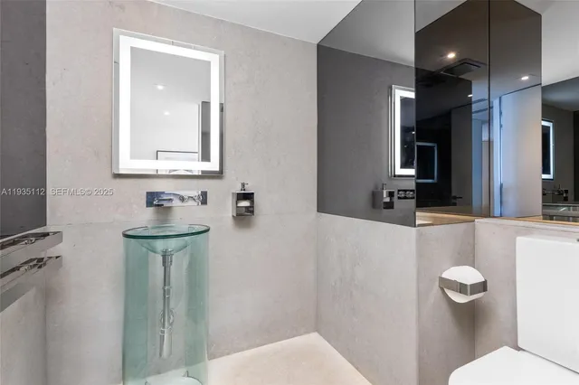 a bathroom with a toilet sink and mirror