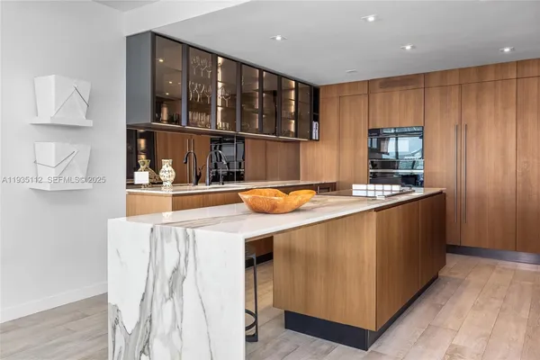 a kitchen with stainless steel appliances granite countertop a sink a stove and a wooden cabinets