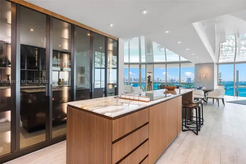 a large kitchen with kitchen island a large counter top space a sink stainless steel appliances and cabinets