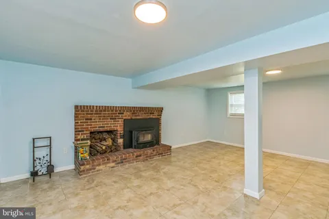 an empty room with fireplace and a window
