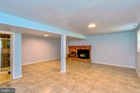 an empty room with wooden floor and a fireplace