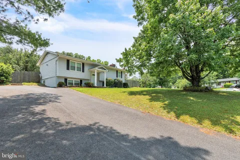 a view of a house with a big yard and large trees