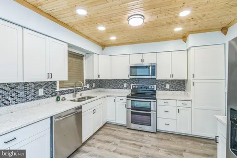 a kitchen with white cabinets and white appliances