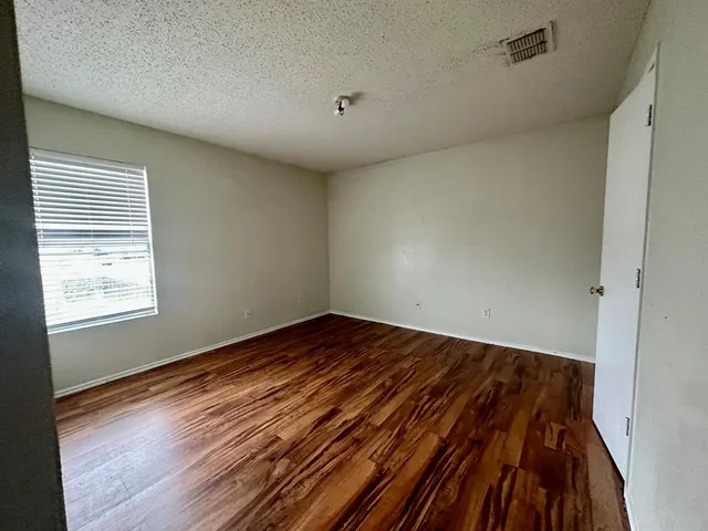 a view of a room with wooden floor and cabinet