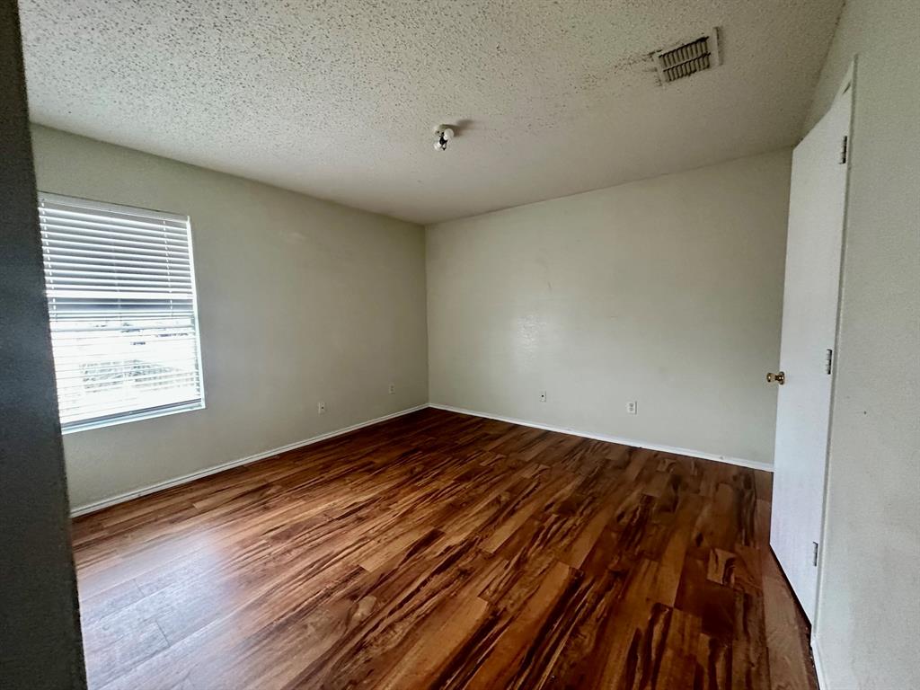 5437 New Castleton Lane Fort Worth, TX 76135 - Photo 11 of 16 a view of a room with wooden floor and cabinet