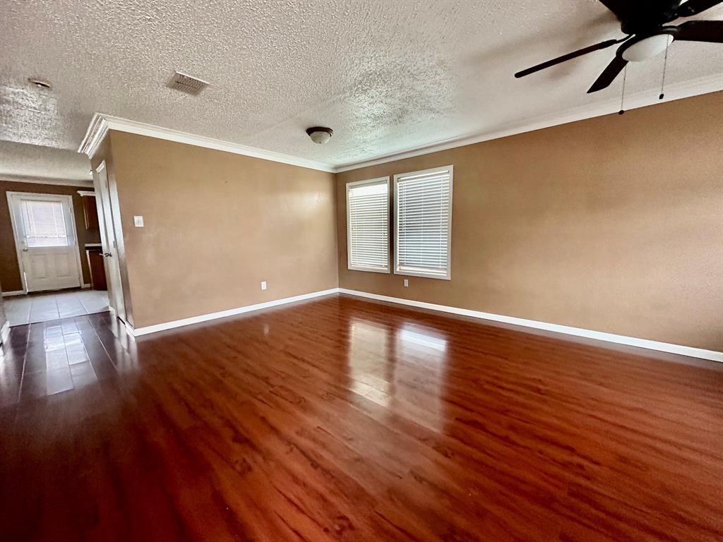5437 New Castleton Lane Fort Worth, TX 76135 - Photo 2 of 16 a view of an empty room with wooden floor and a window