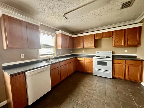 a kitchen with a stove sink and cabinets