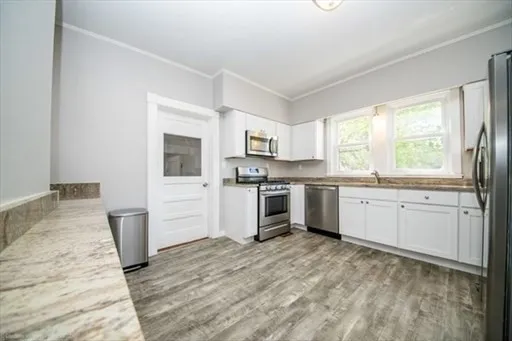 a kitchen with granite countertop white cabinets and white appliances