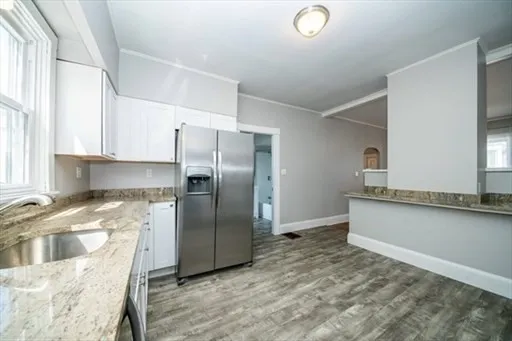 a kitchen with granite countertop a refrigerator and a sink
