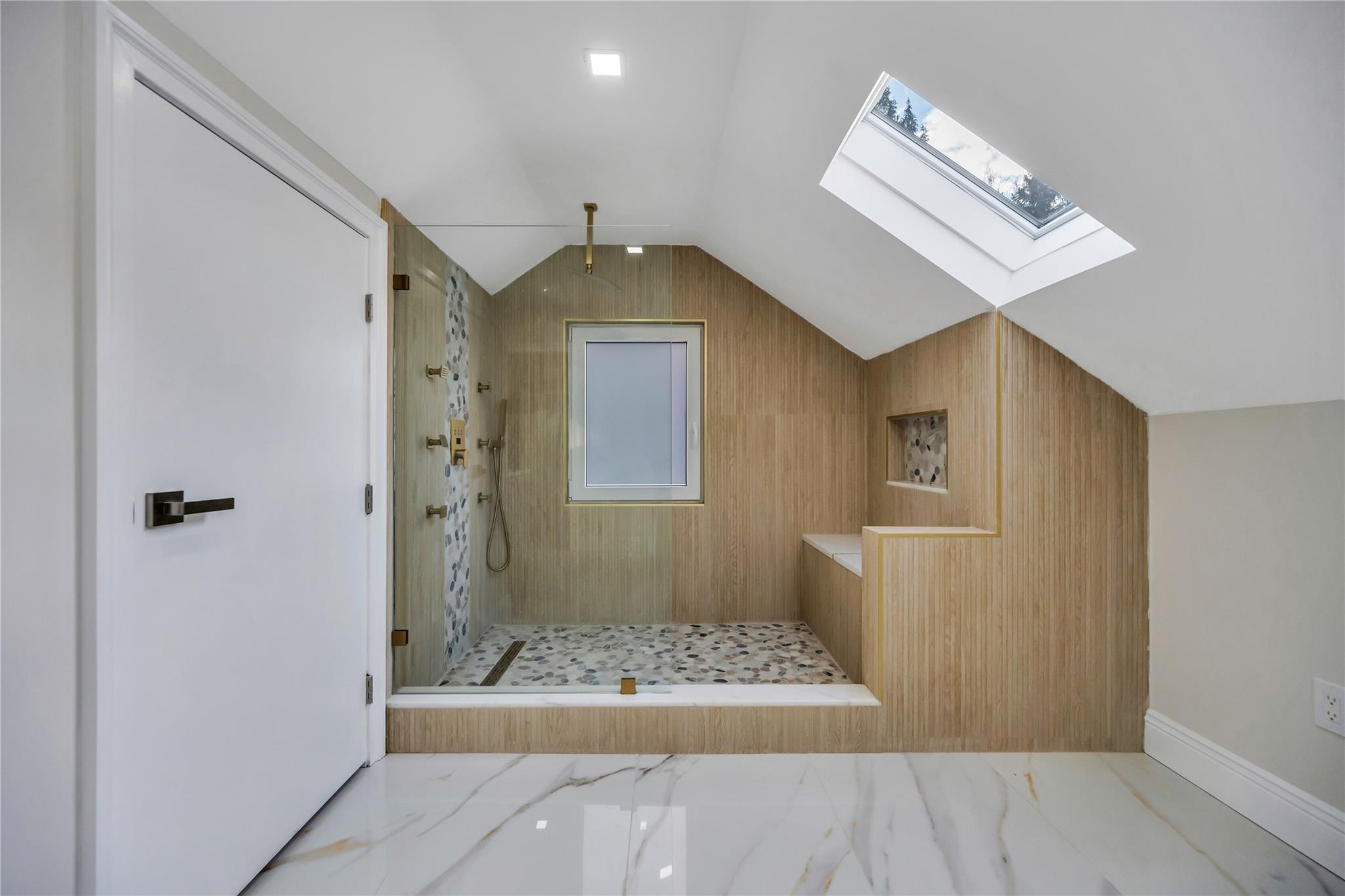 503 Bayville Road Locust Valley, NY 11560 - Photo 11 of 26 Bathroom featuring lofted ceiling with skylight, wooden walls, and tiled shower