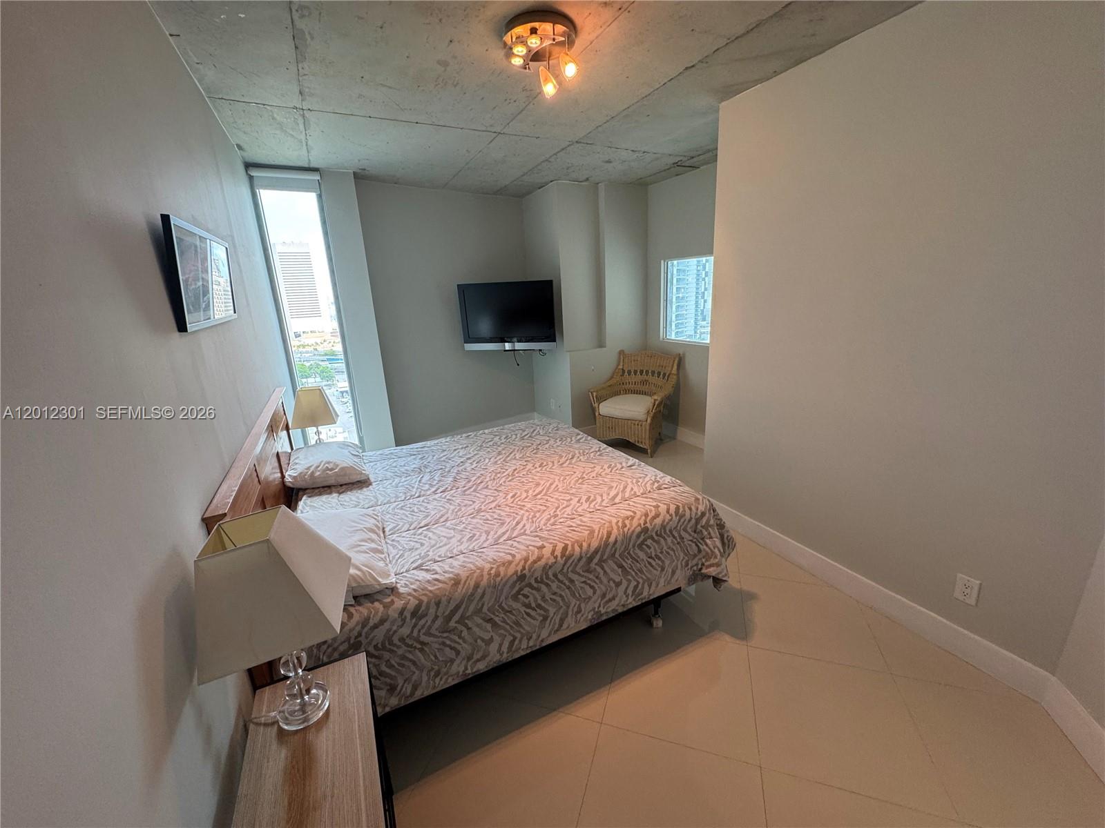 690 Southwest 1st Court, Unit 2301 Miami, FL 33130 - Photo 19 of 26 a bedroom with a bed and a chandelier