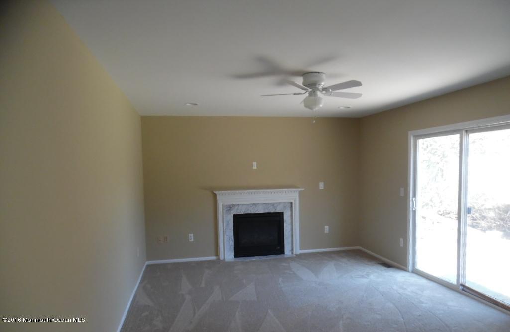 116 Lanyard Road Manahawkin, NJ 08050 - Photo 4 of 11 an empty room with chandelier fan and windows