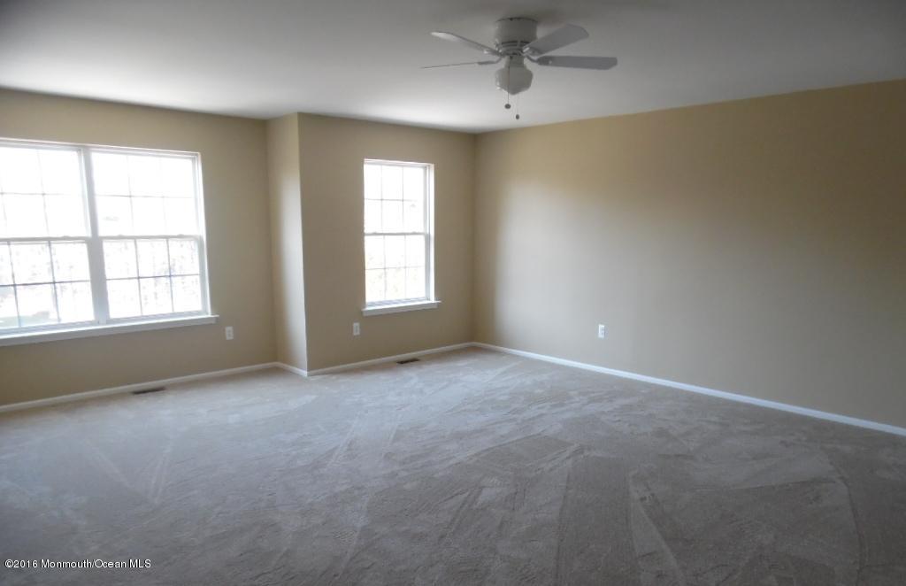 116 Lanyard Road Manahawkin, NJ 08050 - Photo 6 of 11 an empty room with windows and chandelier fan