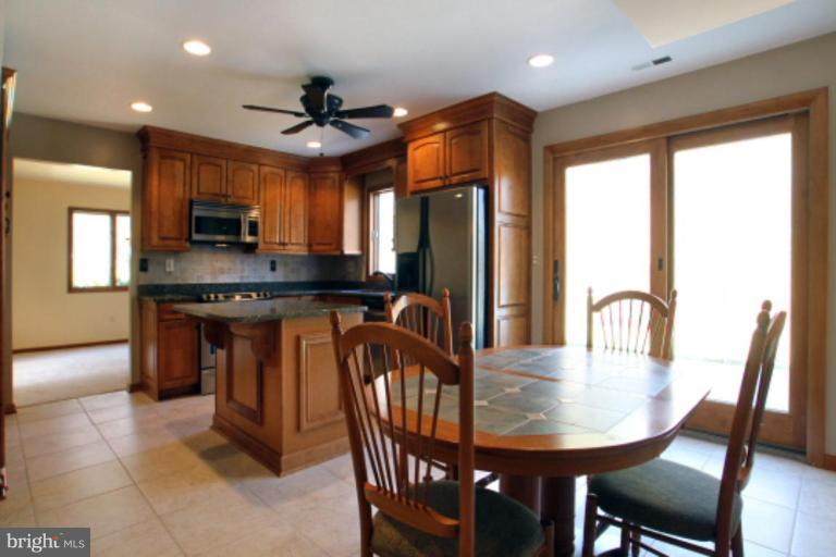 17915 Marshall Mill Road Hampstead, MD 21074 - Photo 14 of 30 a kitchen with stainless steel appliances granite countertop a stove a sink a microwave a dining table and chairs
