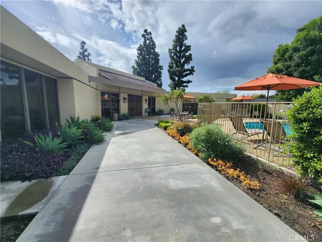 a view of a house with a big yard and a large parking space