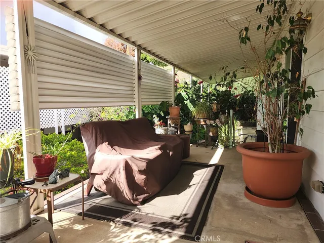 a view of a porch with chairs and potted plants