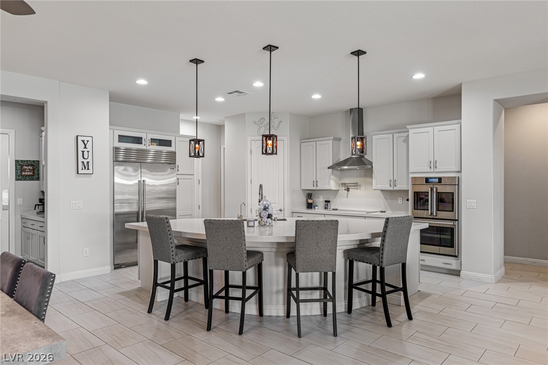 7036 Arabian Ridge Street Las Vegas, NV 89131 - Photo 23 of 64 An inviting kitchen features a grand island with seating for four, complemented by modern appliances and ample cabinetry.