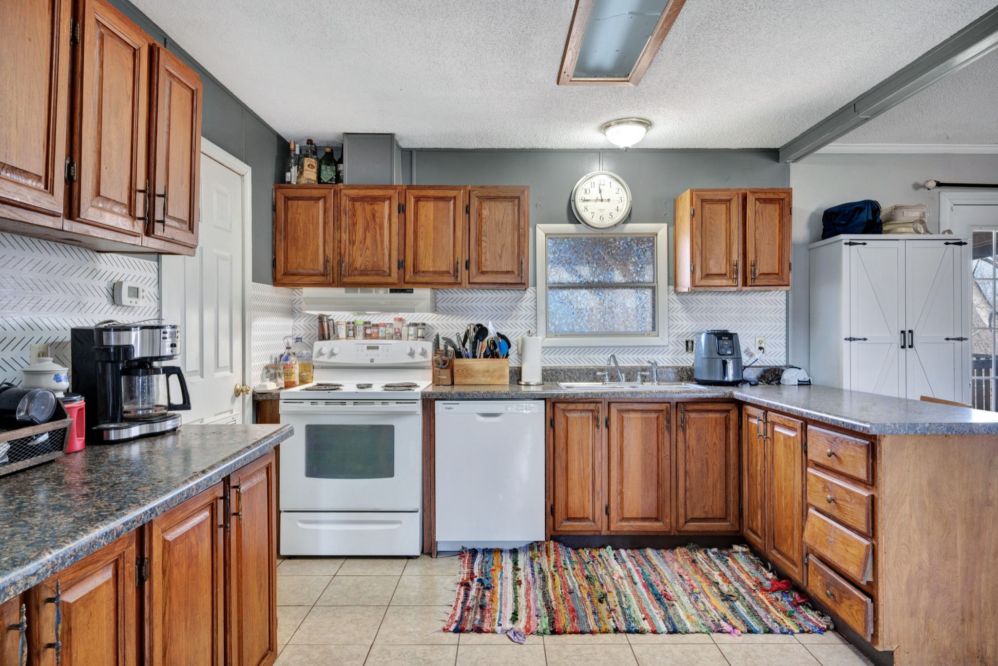 1169 Saddle Tree Road Ashland City, TN 37015 - Photo 9 of 29 a kitchen with a sink dishwasher a stove a microwave oven and cabinets with wooden floor