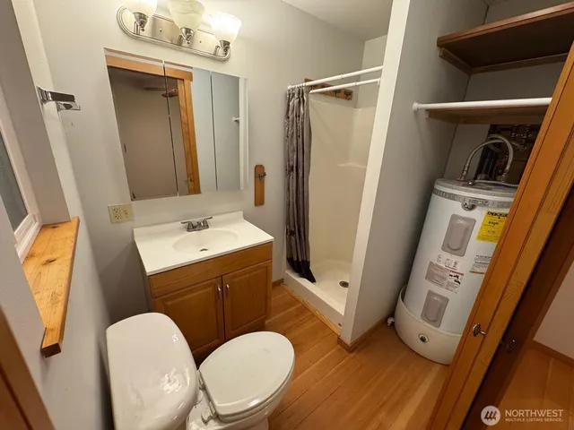 a bathroom with a sink a toilet a mirror and tub