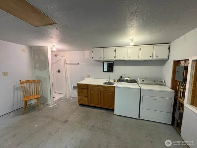 a utility room with cabinets dryer and washer